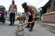 Cegah Laka Lantas, Polisi di Gresik Tambal Jalan Berlubang, Aksinya Menarik Perhatian Pengguna Jalan