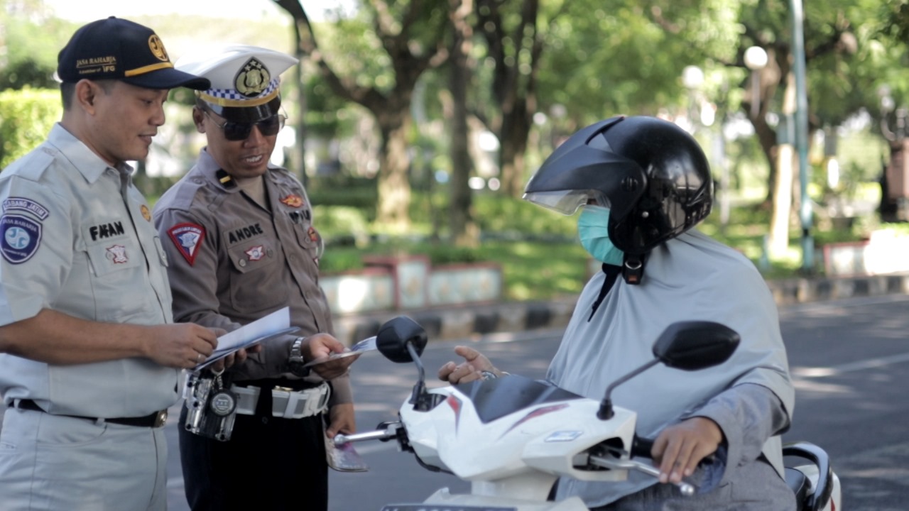 Satlantas Polrse Gresik- Jasa Raharja Bagi Pamflet dan Gantungan Kunci ke Pengguna Jalan